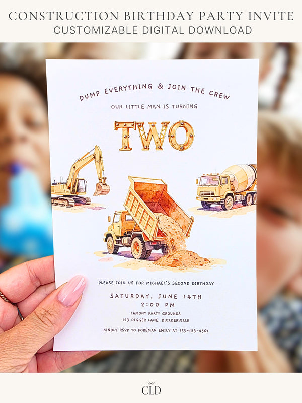 Printable construction birthday invitation held in hand, featuring a watercolour dump truck tipping sand, an excavator, and a cement mixer beneath the word TWO in industrial scaffolding lettering. Header reads Dump Everything and Join the Crew. Designed by ChelseaLamontDesign.