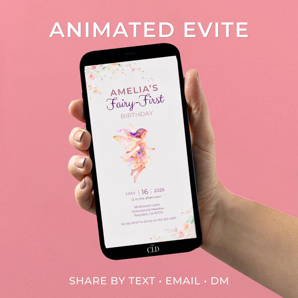 Hand holding a smartphone displaying an animated Fairy First Birthday invitation with a pastel watercolor fairy floating gently, soft floral accents, and elegant purple typography reading “Amelia’s Fairy-First Birthday” on a light neutral background.