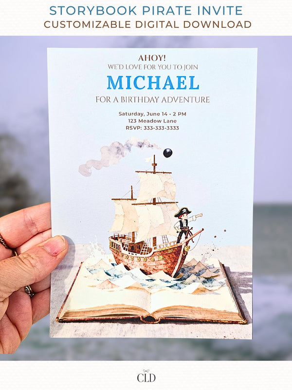 A hand holding a printed pirate birthday invitation showing a watercolor pirate ship sailing out of an open storybook, with paper-style waves, a cannonball, and the birthday details printed above in blue and brown text.