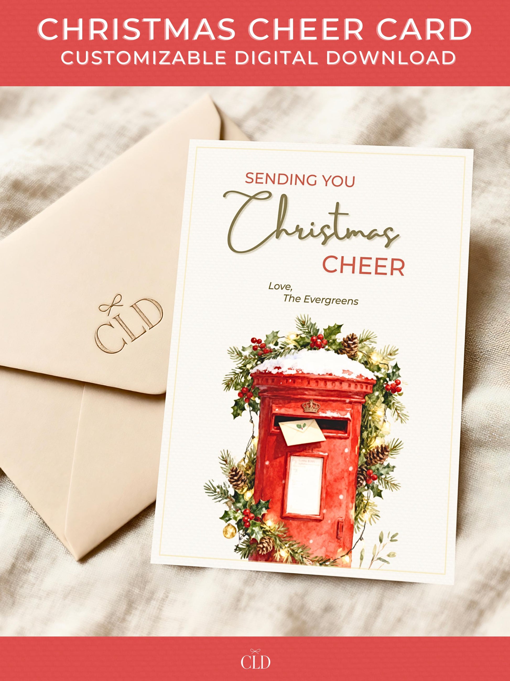 Printable Christmas card featuring a classic red British postbox surrounded by festive greenery, pinecones, and gold lights, with text reading ‘Sending You Christmas Cheer’. Displayed on a beige envelope with soft holiday lighting