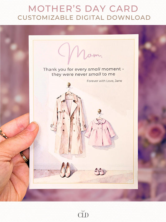 Hand holding a soft watercolor Mother’s Day card featuring a beige trench coat and a pink children’s coat with matching shoes, elegant script reading ‘Mom,’ and a warm, blurred pink floral background. Modern, feminine, high-end card mockup with CLD branding.