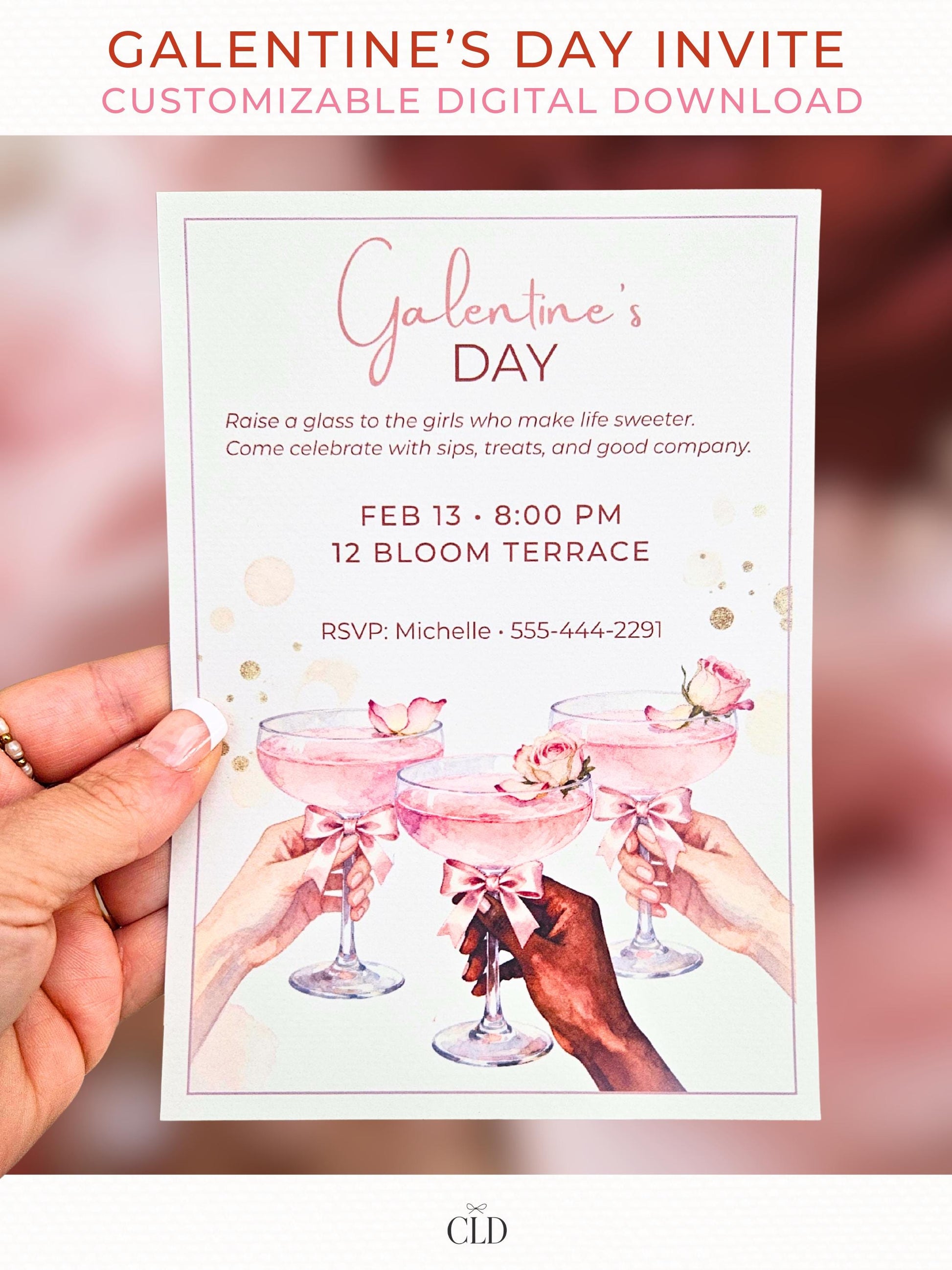 Hand holding a blush pink watercolor Galentine’s Day invitation featuring three women’s hands raising rose cocktails with bows, shown against a soft Valentine-themed bokeh background