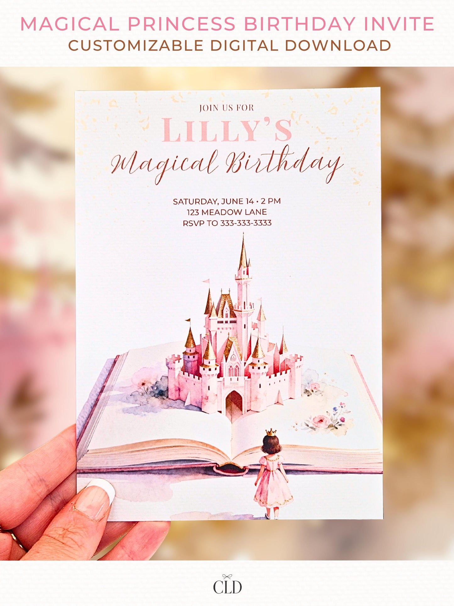 Close-up photo of a hand holding a printed fairytale-style princess birthday invitation featuring a pink castle rising from an open storybook, soft blush tones, and watercolor details. Light, magical background with warm tones.